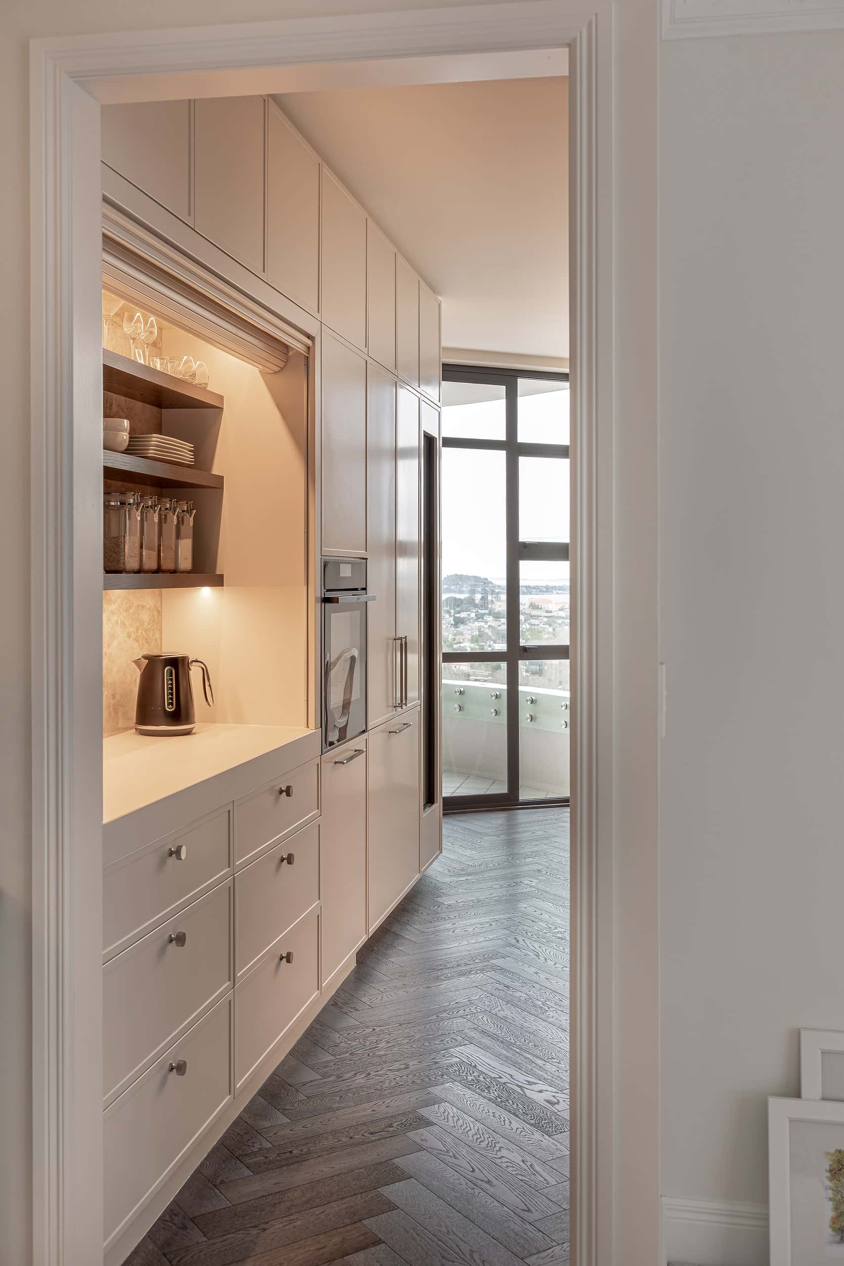 Cream white kitchen in-built cabinetry with roller door